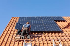 Solarpanel auf Dach mit Monteur